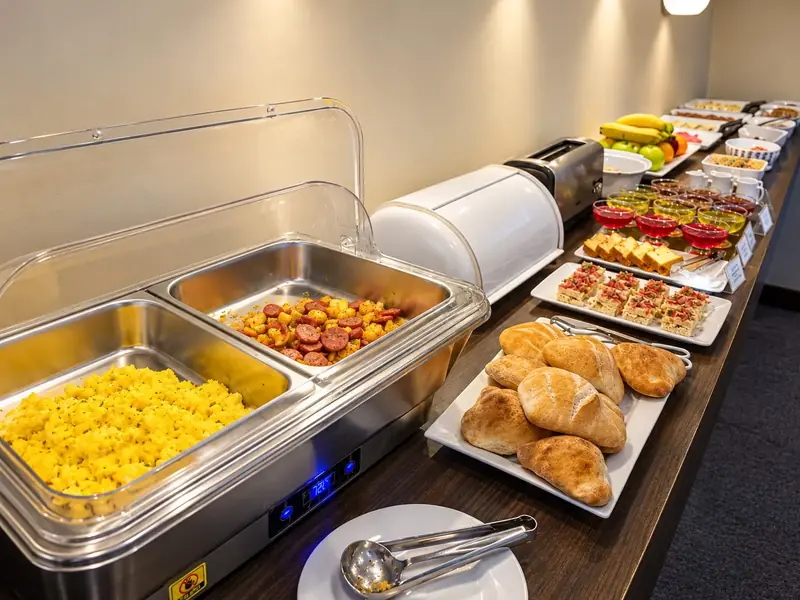 Buffet de desayuno con panes y platos calientes