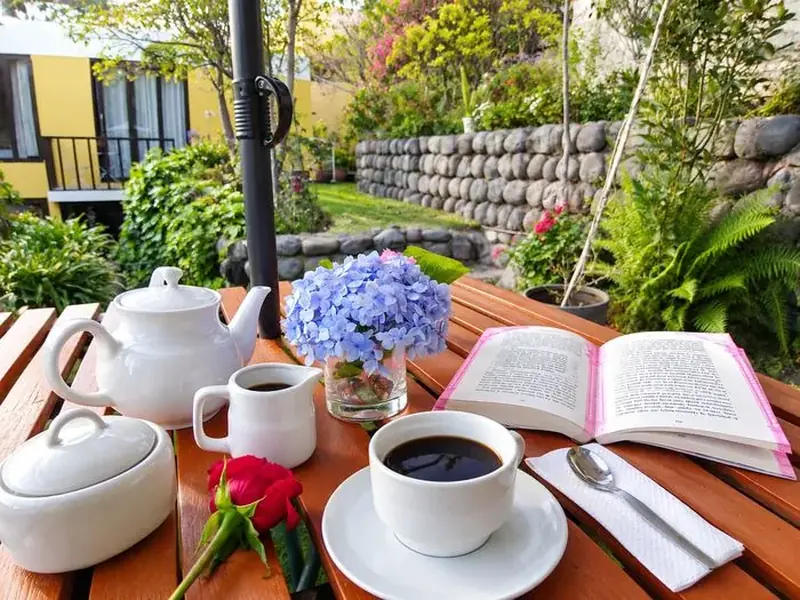 Café y un libro abierto en la terraza del jardín