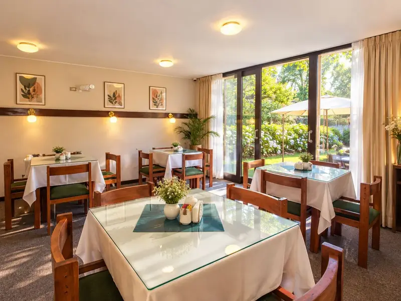 Comedor con ventanales hacia el jardín