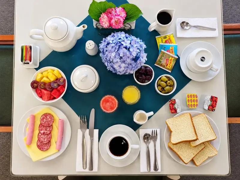 Desayuno servido: fruta, panes, jugos y café